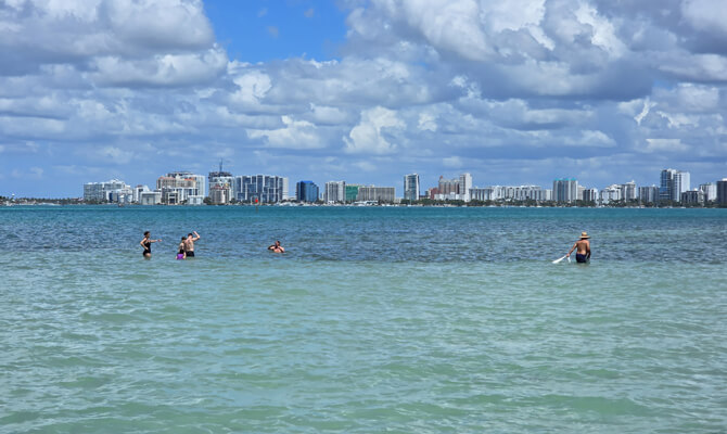 Standing in shallow sandbar water during Siesta Key boat tour