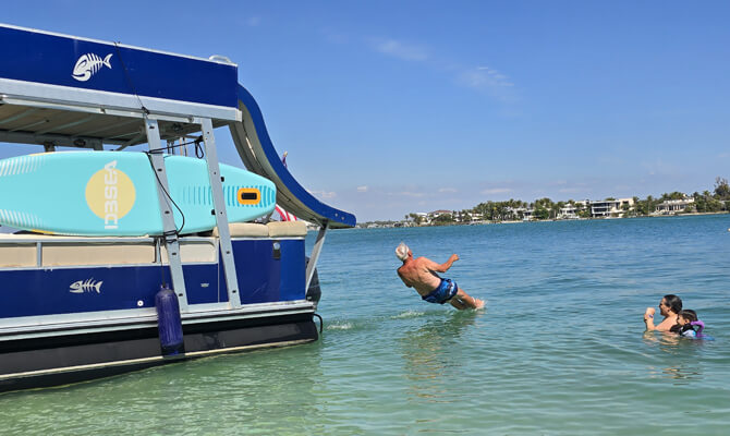Splashing into Sarasota Bay from boat waterslide during tour